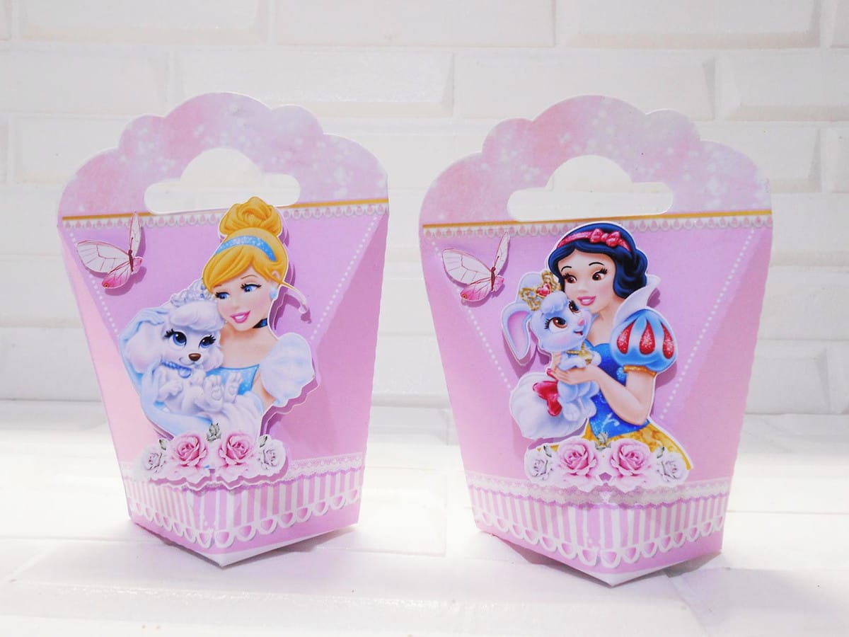 Monte uma Festa Princesas Disney com Kit Digital Completo 2 Duas caixas de papel rosa decoradas com personagens femininas e animais.