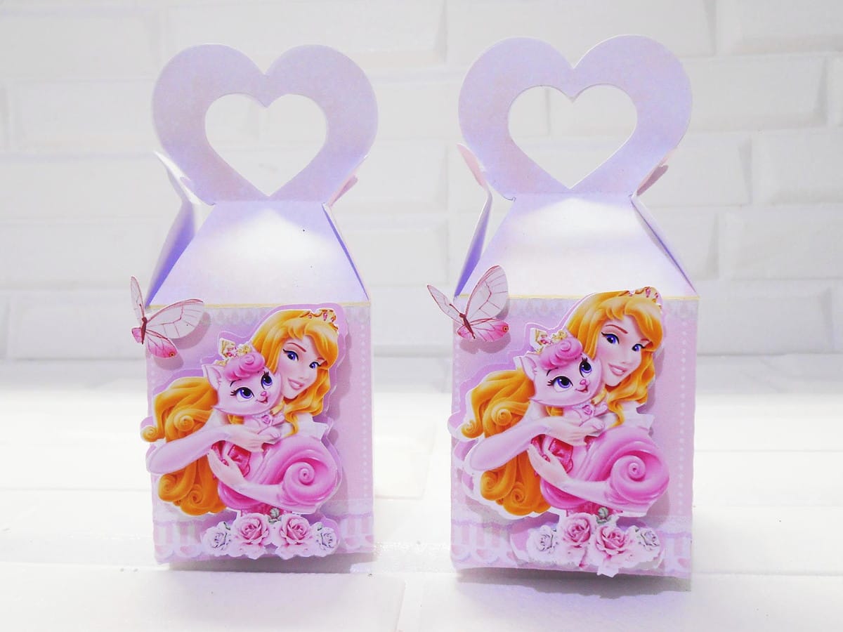 Monte uma Festa Princesas Disney com Kit Digital Completo 3 Duas caixas de papel rosa decoradas com personagens e alças em formato de coração
