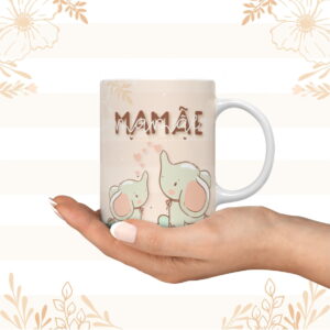 Mão humana segurando uma caneca branca estampada com elefantes fofos.
