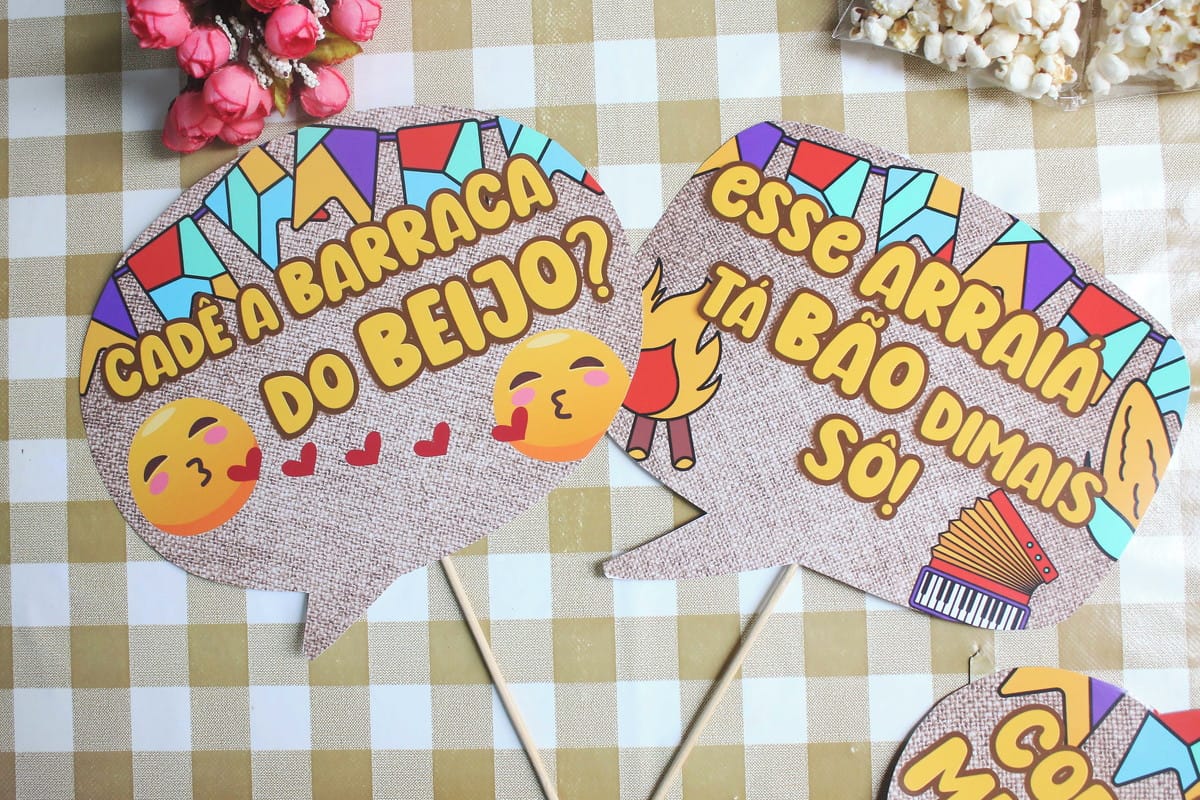 Plaquinhas de Festa Junina Arquivo de Corte para Imprimir 2 Placas decorativas temáticas de festa com frases, emojis e ilustrações coloridas sobre fundo xadrez.