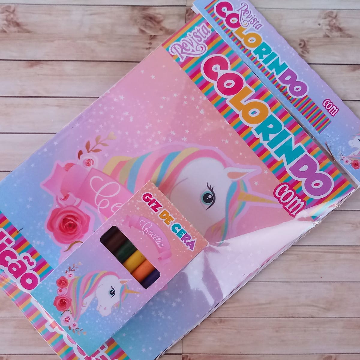 Revistinha para Colorir Unicórnio com Nome da Criança 2 Revista de colorir com estampa de unicórnio e caixa de giz de cera.