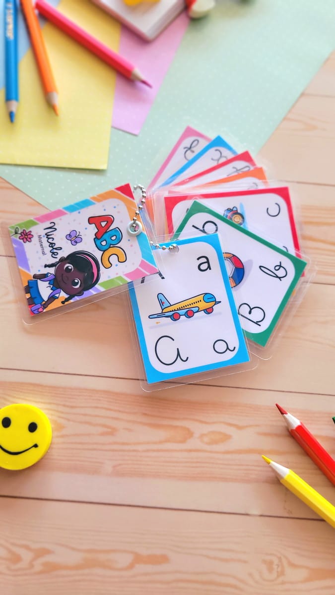 Kit Volta às Aulas 2024 com Mais de 200 Ilustrações 2 Flashcards educativos coloridos com letras e ilustrações, cercados por material escolar.